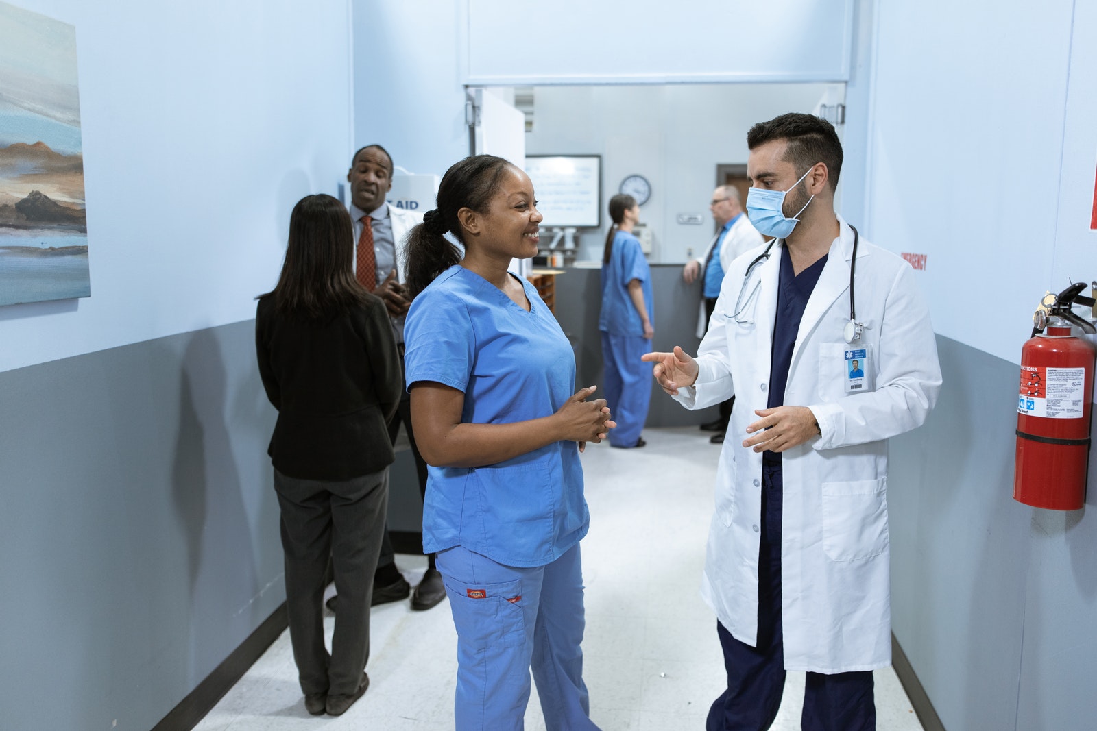 A nursing student talking to a resident doctor.