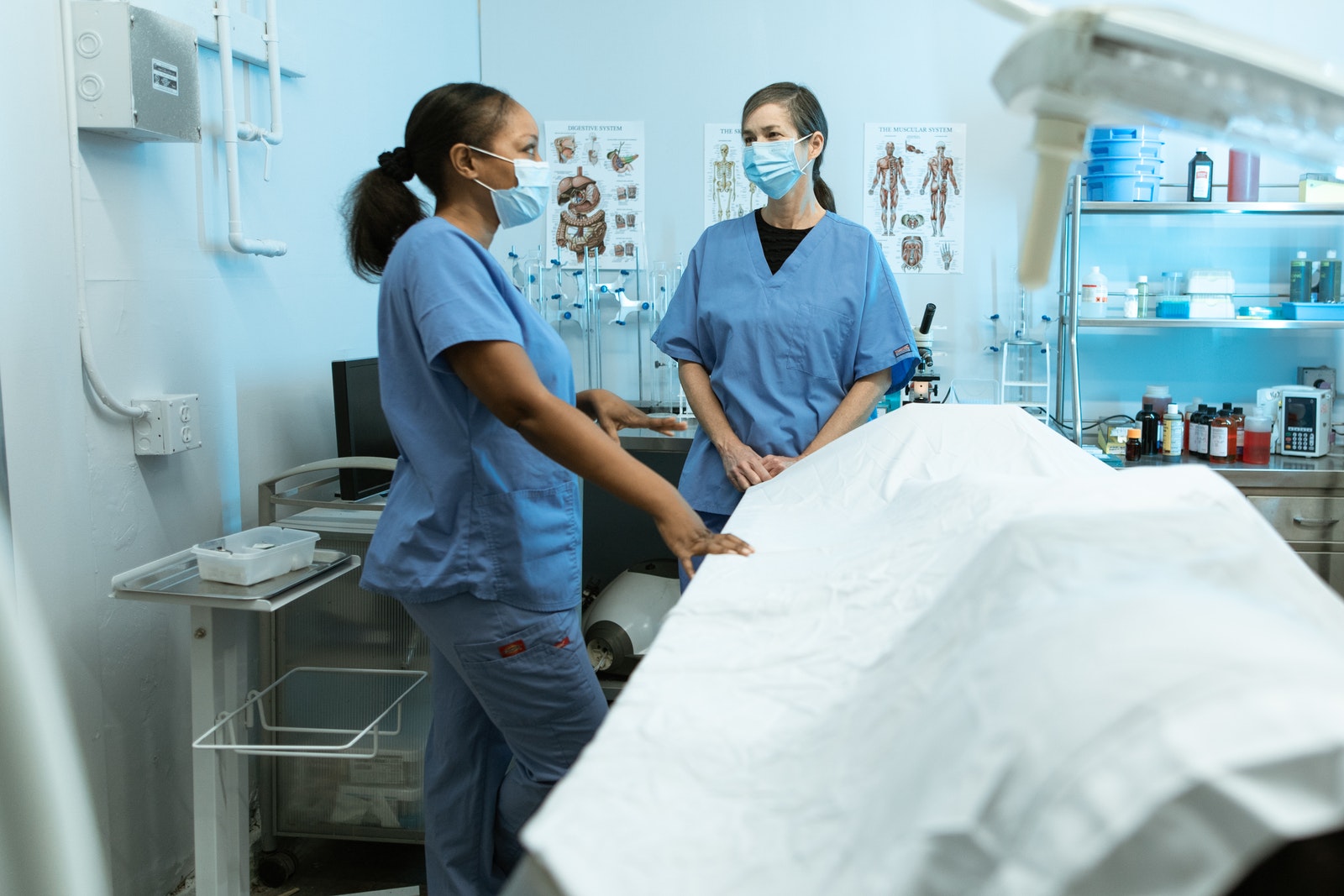 Woman in Blue Scrub Suit Holding White Printer Paper