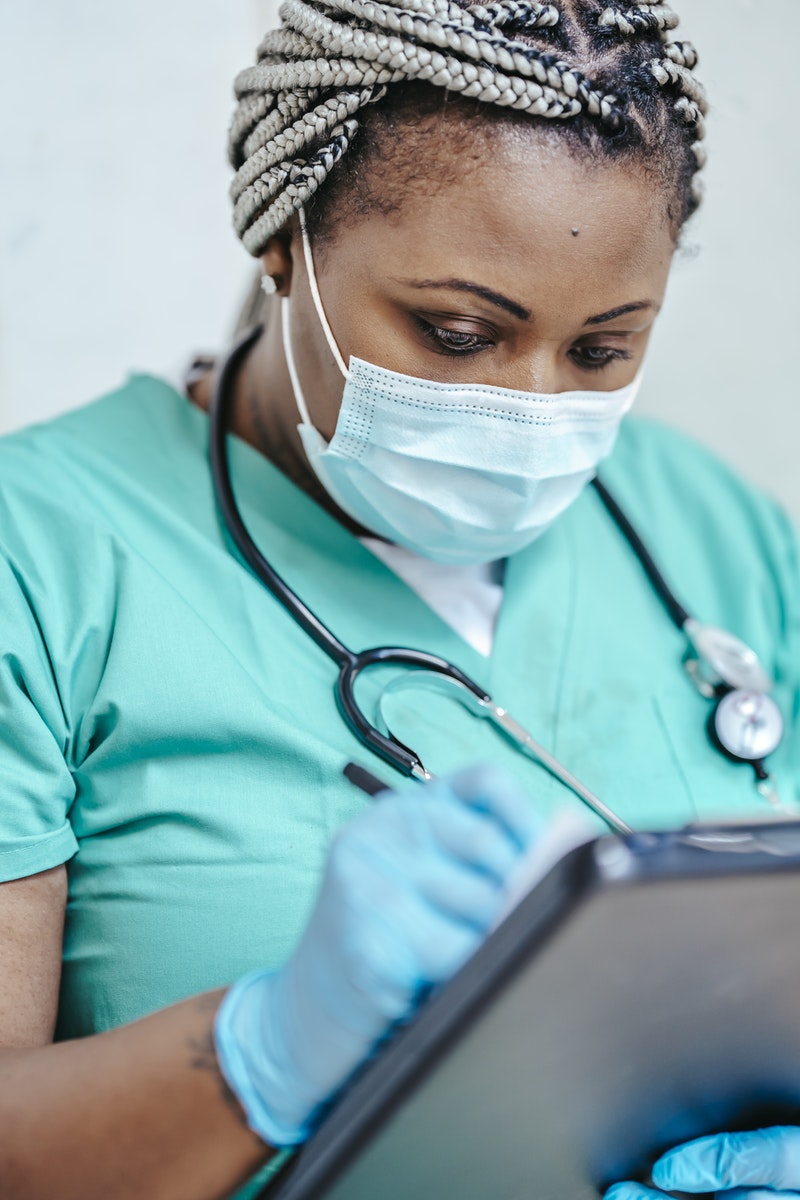 A travel nurse writing prescription on paper