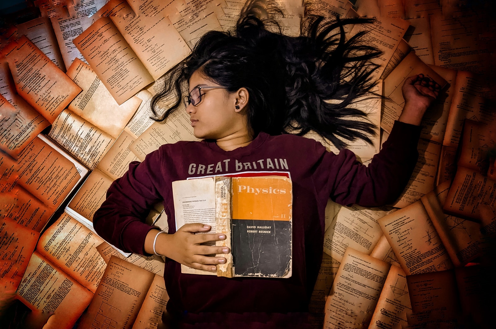 A girl laying on books