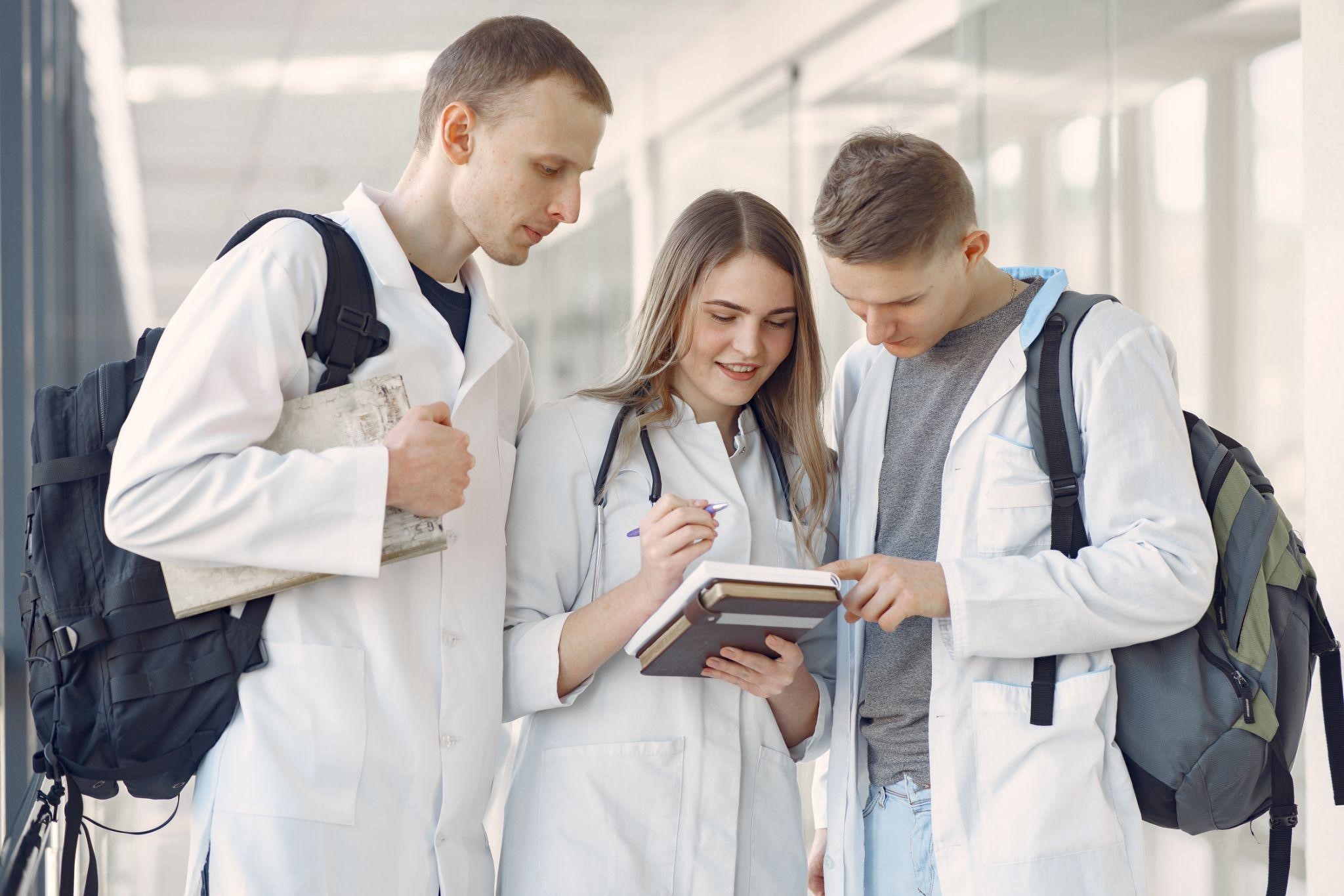 Three medical students looking at a note